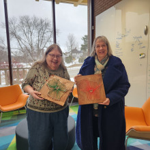 Two artisans with their string art projects.