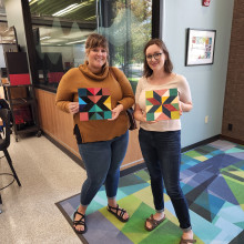 Two artisans with their barn quilt projects.